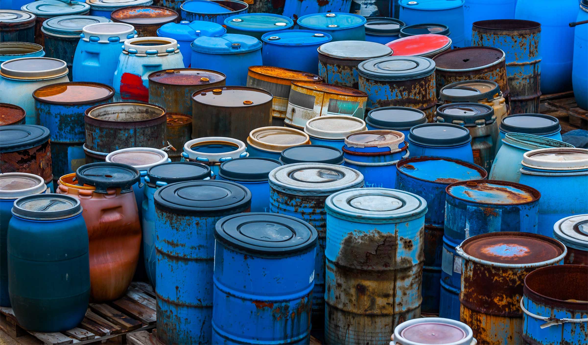 Rusty oil drums in large dump site