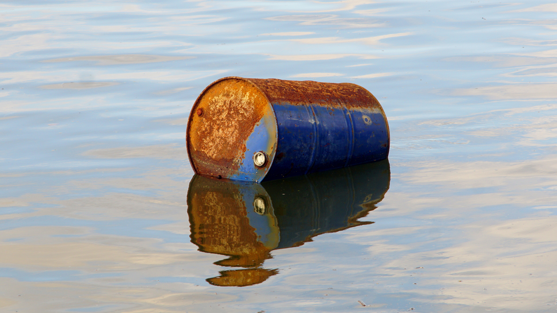 rusty oil barrel floating in water